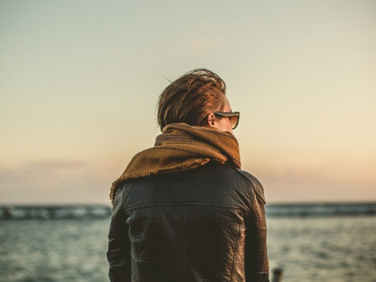 woman-by-the-water-wearing-leather-jacket-scarf-sunglasses